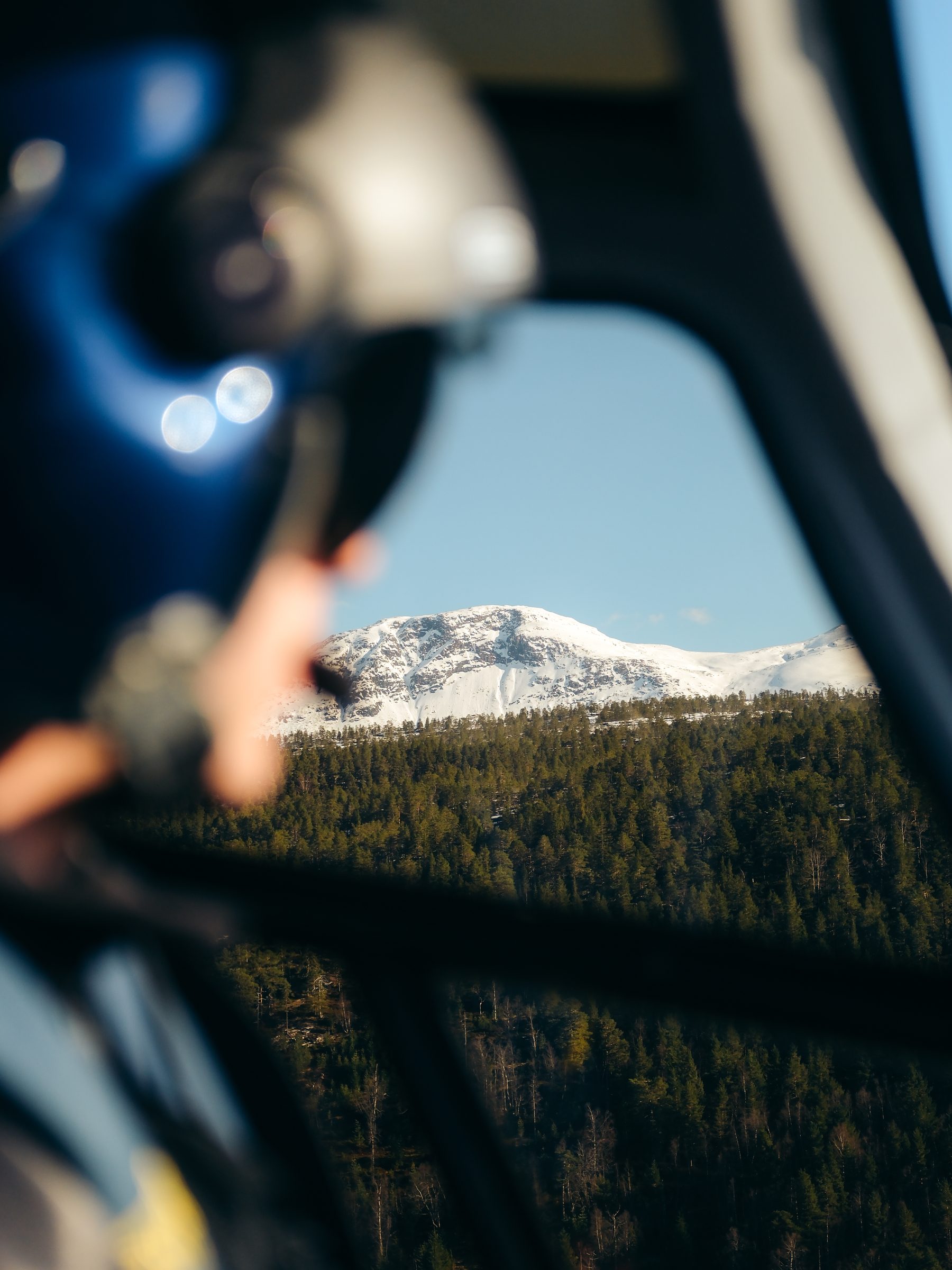 View of a snowy mountain through the helicopter window.