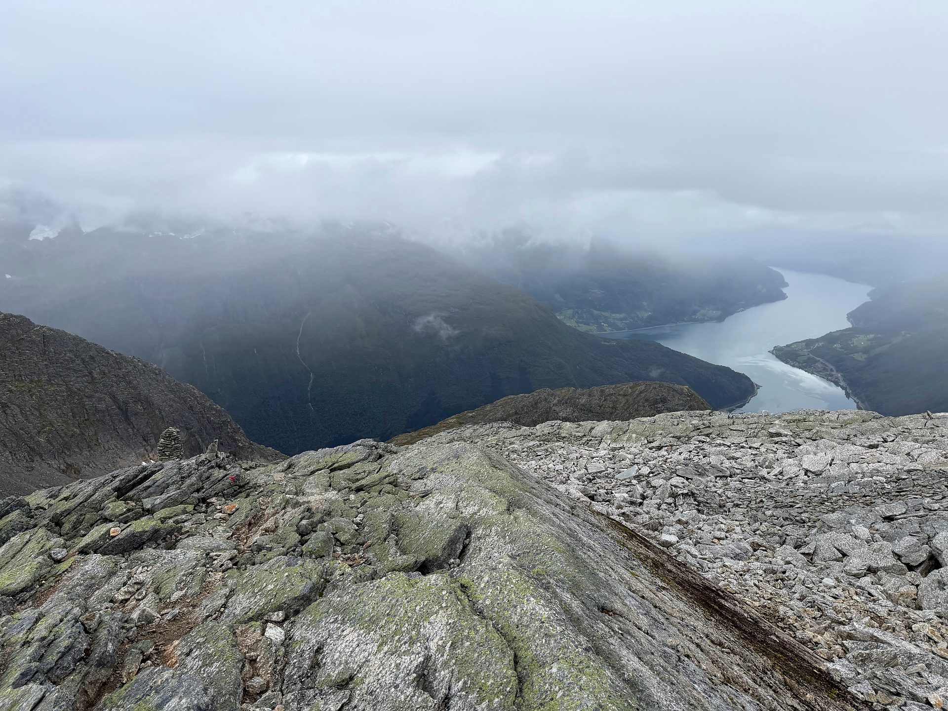 View from high on Skåla down to the fjord, with low cloud over the mountains.