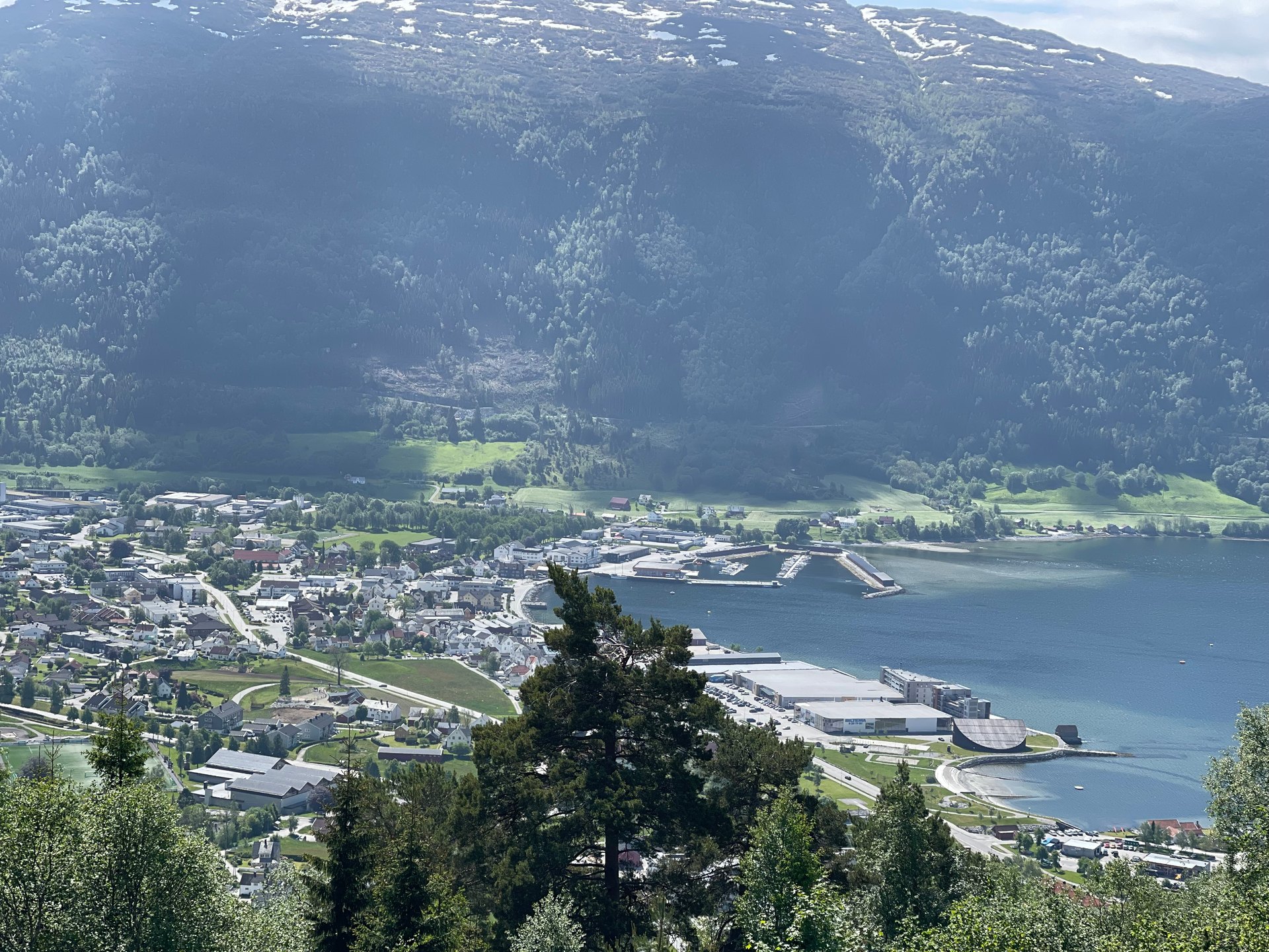 The view from Utsikta over Nordfjordeid: the village, the pier and the fjord, with the mountains behind