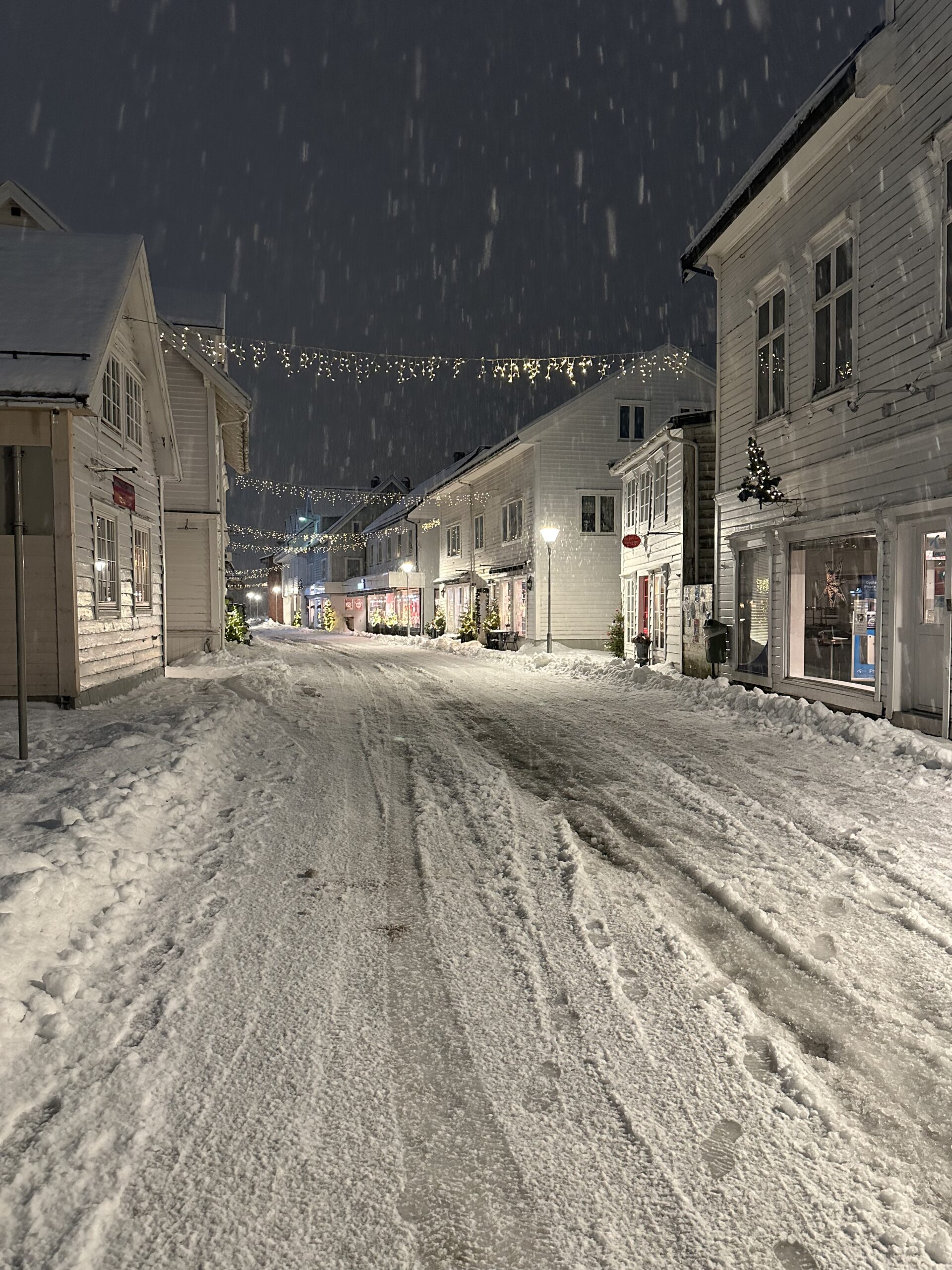 Eidsgata, the old main street of Nordfjordeid, with its white wooden houses lit up on a snowy winter evening